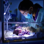 Indian NICU nurse comforting a critically ill baby in emergency neonatal care