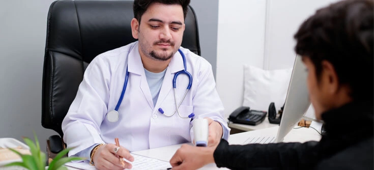 General physician consulting adult patient in hospital outpatient department