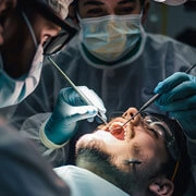 ENT surgeon performing tonsillectomy and adenoid surgery for chronic tonsillitis treatment in hospital operating room