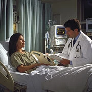 Doctor evaluating patient recovery and confirming discharge readiness in hospital room