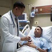 Doctor explaining medication prescription, diet recommendations and wound care instructions to patient before hospital discharge